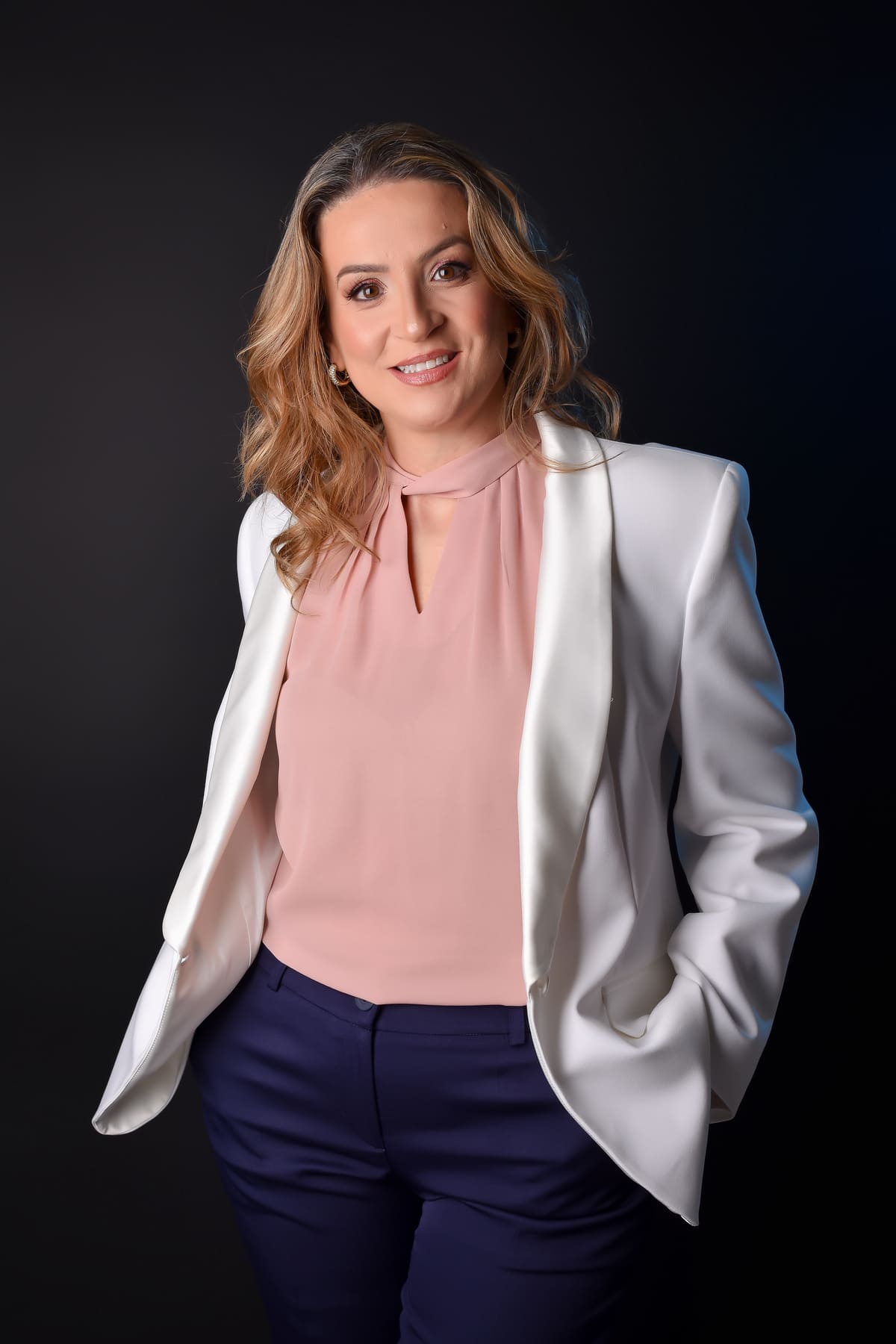 Empresária em blazer branco e blusa rosê