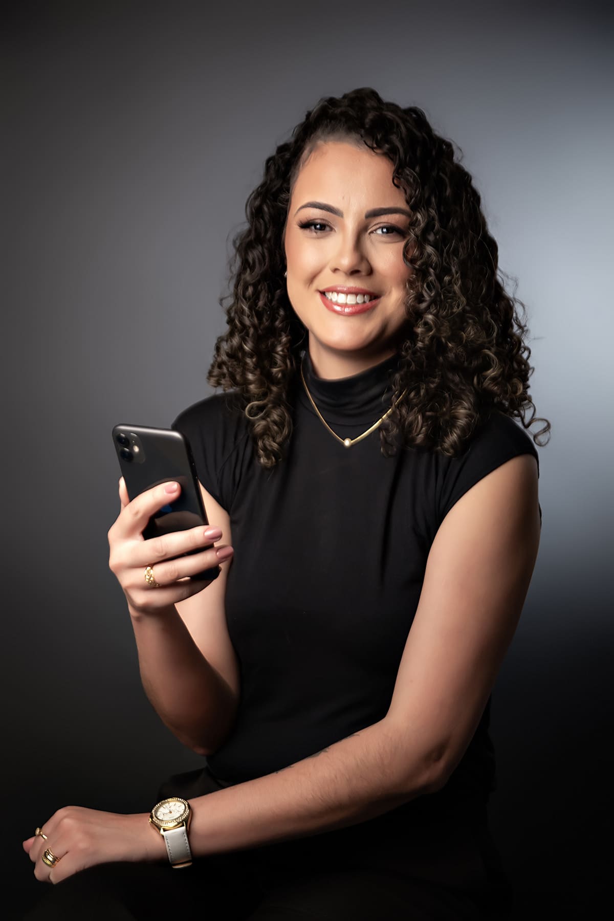 Mulher de cabelo cacheado segurando o celular